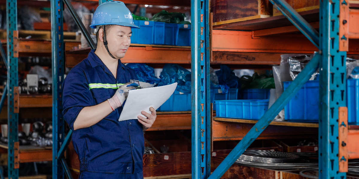 a worker of dombor in blue dress recording on paper